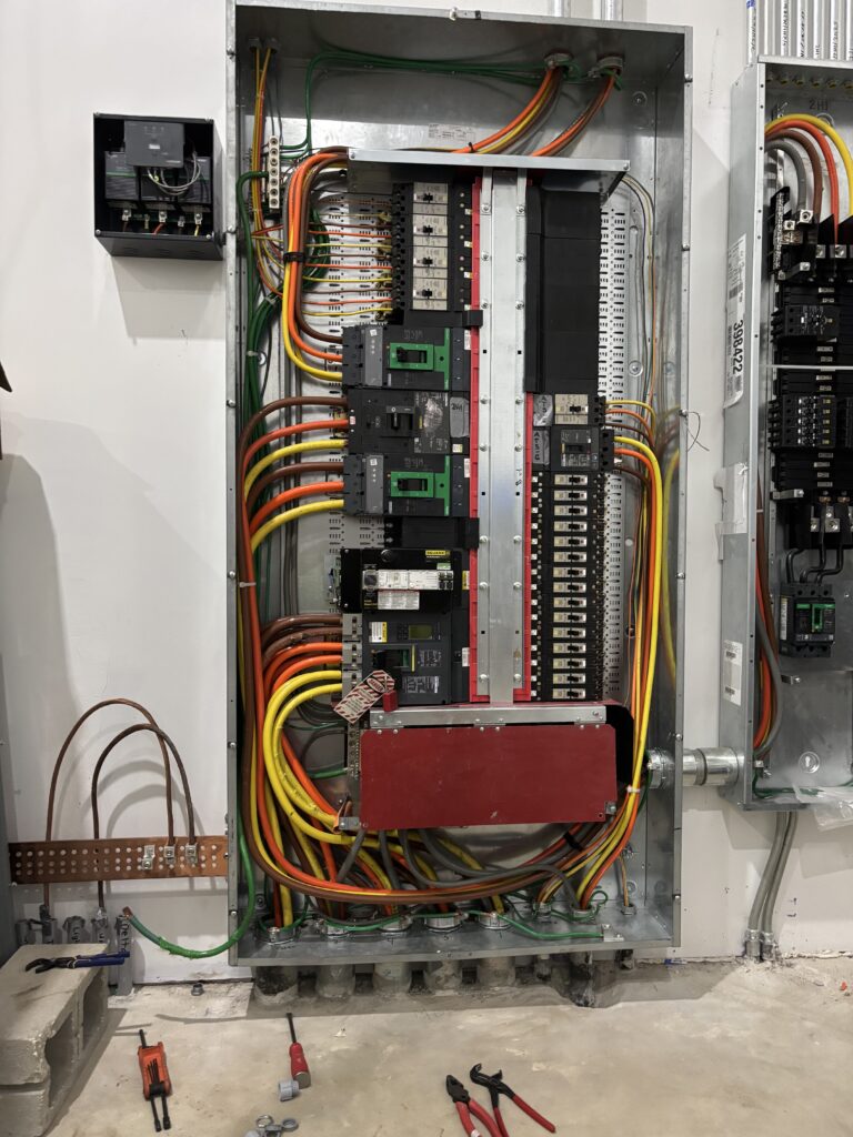 Open electrical panel with colorful wiring and tools