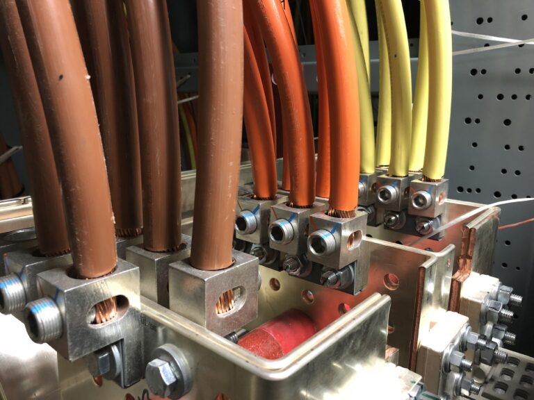 Colorful insulated cables connected to metal busbar